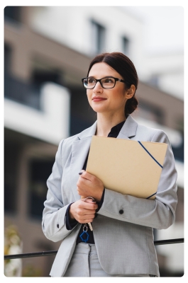 Woman holding folder in front of building